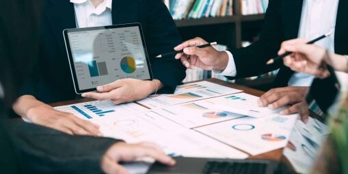 Private equity team pointing at lead time reduction charts during a meeting