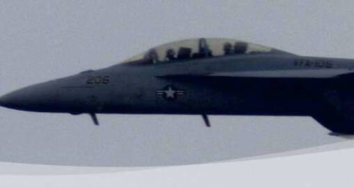A military fighter jet with a gray body and visible cockpit flies against a cloudy sky, showcasing operational excellence. The aircraft has 206 and a star insignia on its side.